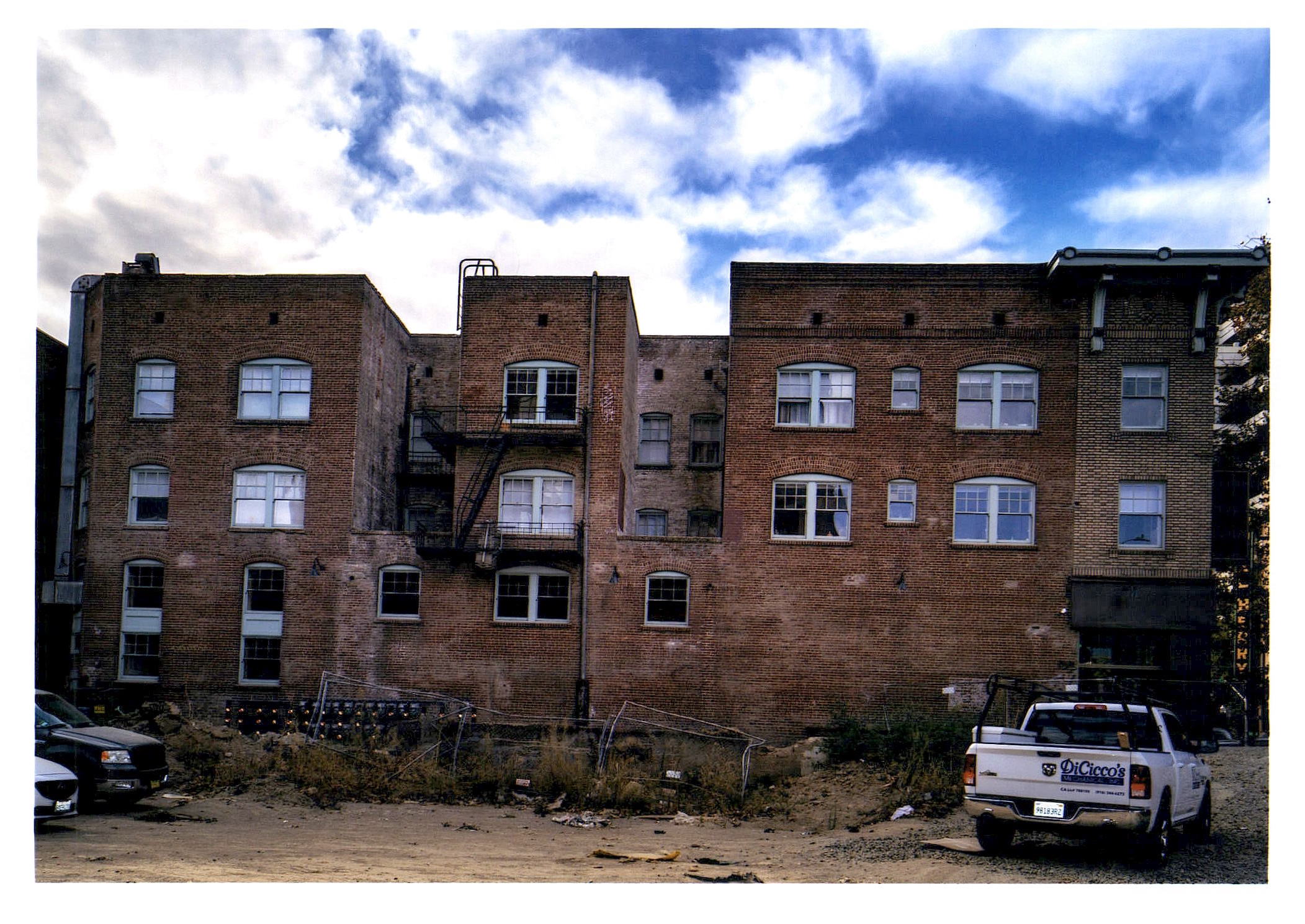 After: side view of north facade on alley, showing restored apartment windows.